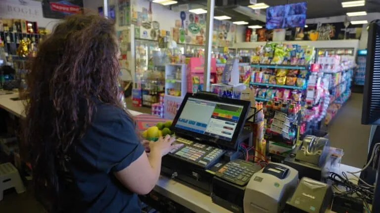 A store owner ringing up a sale at the register